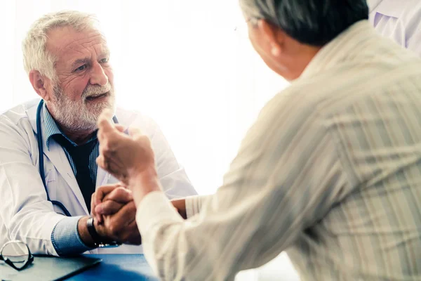 Senior arts praten met de patiënt in het ziekenhuis. — Stockfoto