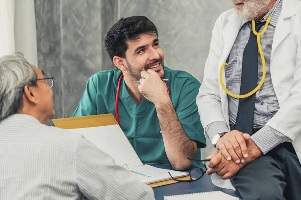 Erkek doktor ekibi kıdemli hasta ziyareti ile konuşuyor — Stok fotoğraf