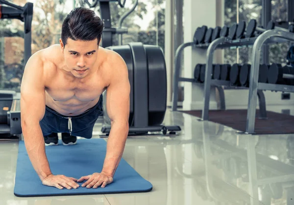 Hombre joven culturista empujar hacia arriba en el gimnasio . —  Fotos de Stock