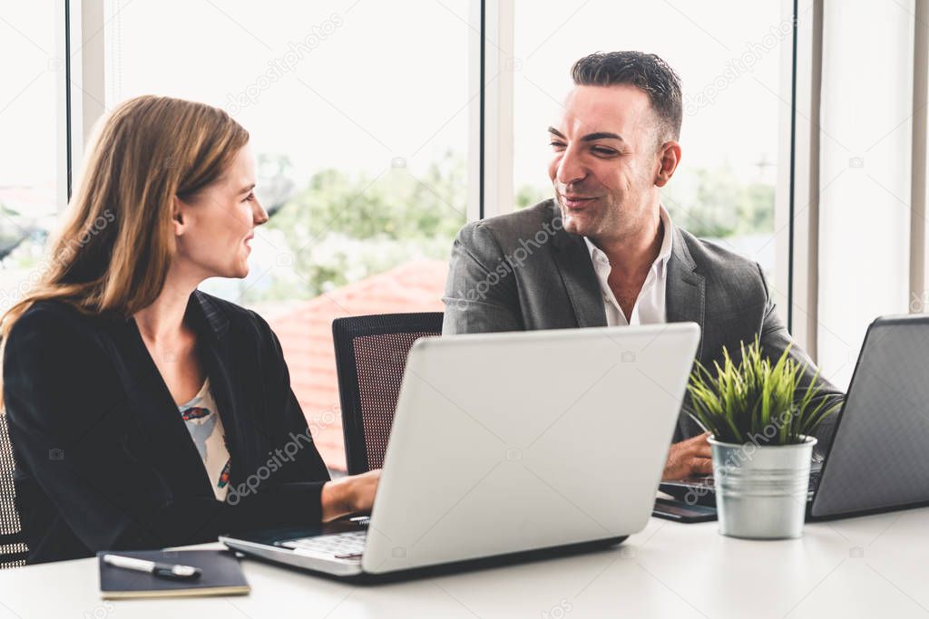 Businessman and businesswoman working in office.