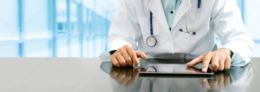 Doctor with tablet computer at hospital office.