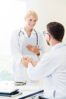 Hastanedeki doktor başka bir doktorla el sıkışıyor