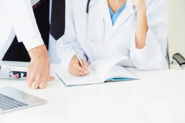 Doktor başka bir doktorla masada rapor yazıyor..