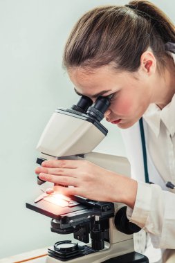 Hastane laboratuvarında mikroskop kullanan doktor.