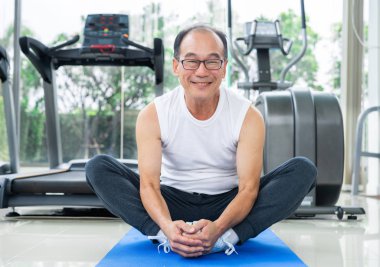 Kıdemli adam fitness merkezinde vücut germe yapmak.