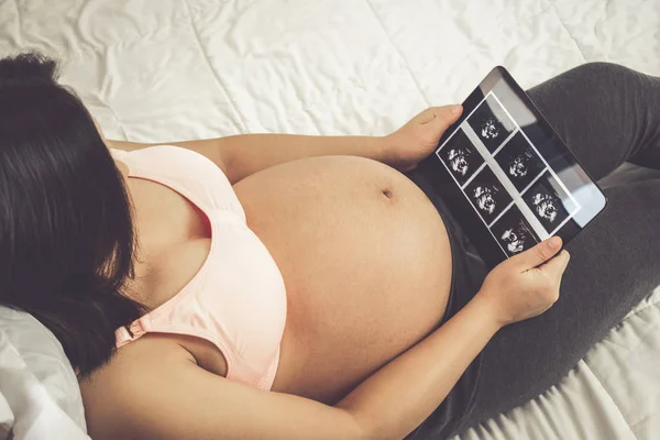 Glückliche Schwangere und erwartetes Baby zu Hause. — Stockfoto