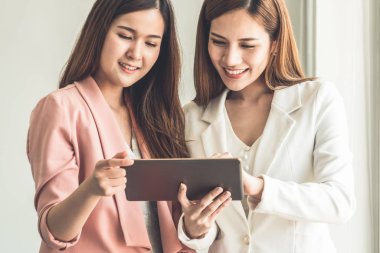 Ofiste tablet bilgisayar kullanan iş kadınları.