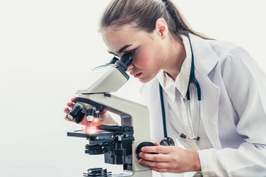 Hastane laboratuvarında mikroskop kullanan doktor.