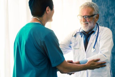 Başka bir doktorla çalışan kıdemli erkek doktor.