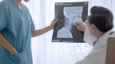 Doktor ve hemşire x-ray görüntü o ameliyat sonucu göstermek tartışmak