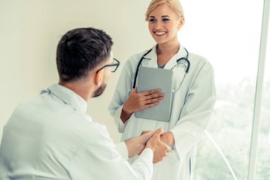 Hastanedeki doktor başka bir doktorla el sıkışıyor