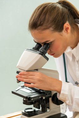 Hastane laboratuvarında mikroskop kullanan doktor.