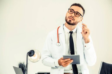 Hastanede tablet bilgisayar üzerinde çalışan doktor.