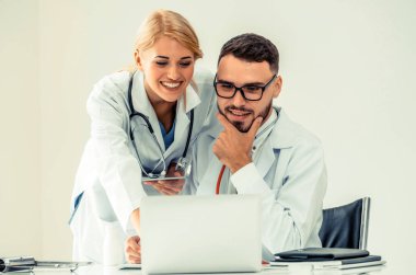 Hastanedeki doktor ortağıyla bilgisayar başında çalışıyor.