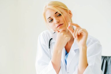 Elinde ilaç hapı tutan genç kadın doktor