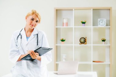 Hastane ofisinde çalışan genç kadın doktor.