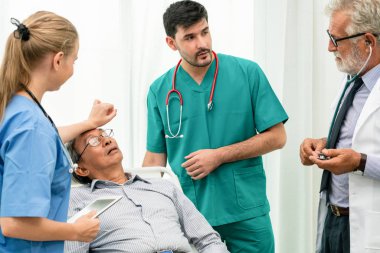 Doktor ekibi hastane koğuşunda yatan kıdemli yetişkin hastayla ilgileniyor. Tıbbi sağlık personeli hizmet tedavi konsepti.