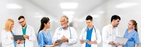 Médico que trabalha no hospital com outros médicos . — Fotografia de Stock