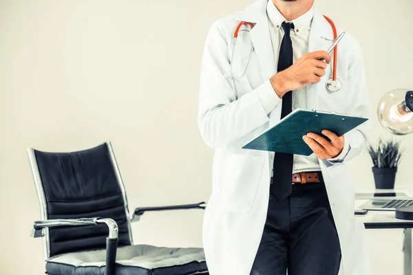 Doctor holding patients health file in hospital.