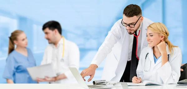 Dokter werkzaam in het ziekenhuis met andere artsen. — Stockfoto