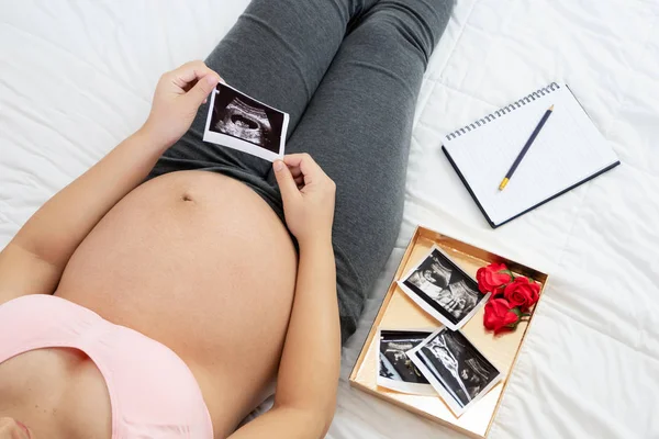 Mujer embarazada feliz y esperando un bebé en casa. — Foto de Stock