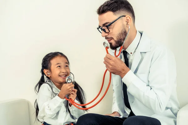 Happy little kid visit doctor in hospital office.