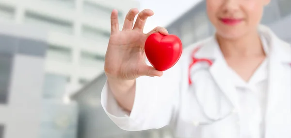 Médecin tenant un cœur rouge au bureau de l'hôpital . — Photo