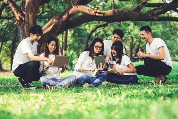 Equipe de jovens estudantes que estudam no parque . — Fotografia de Stock