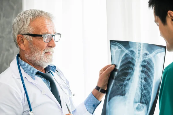 환자 가슴의 엑스레이 필름으로 작업하는 의사. — 스톡 사진
