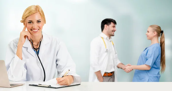 Médico que trabalha no hospital com outros médicos . — Fotografia de Stock