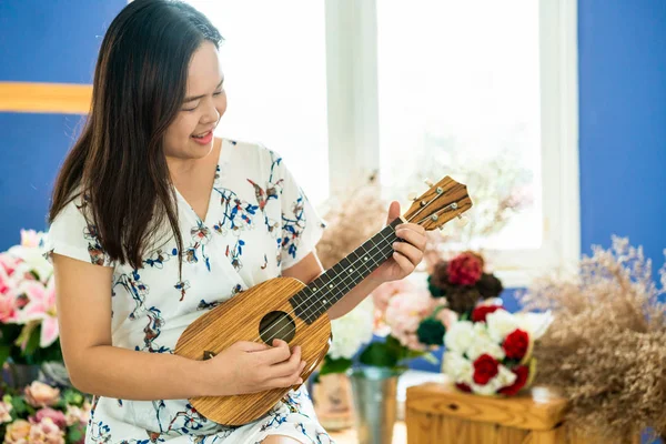 Mulher feliz músico tocando ukulele no estúdio . — Fotografia de Stock