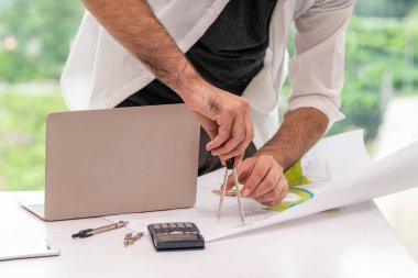 Masa başında çalışan genç mimar veya mühendis.