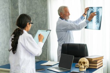 Hasta göğsünün x Ray filmi ile çalışan doktorlar.