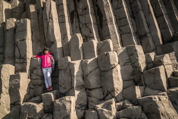 Reiziger op hexagonale rotsen in Vik, IJsland. — Stockfoto