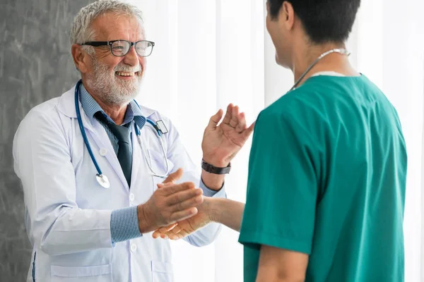 Senior medico di sesso maschile che lavora con un altro medico . — Foto Stock