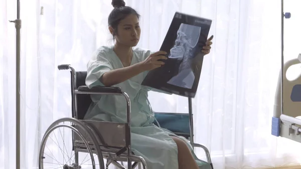 Paciente seria mirando la imagen de rayos X de su aumento de lesiones cerebrales — Foto de Stock