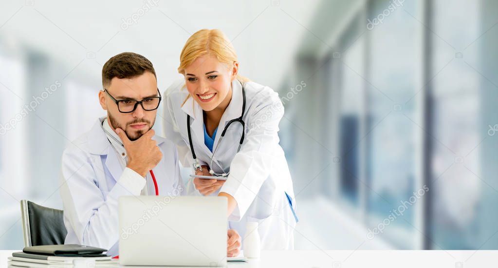 Doctors working with laptop computer in hospital.