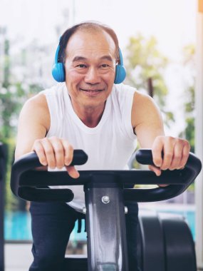 Fitness merkezinde bisiklet makinesi üzerinde Kıdemli adam egzersiz