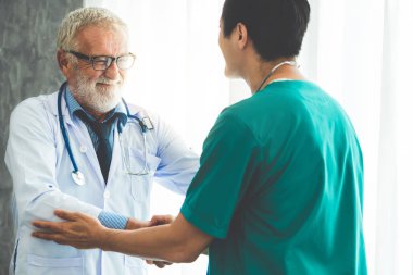 Başka bir doktorla çalışan kıdemli erkek doktor.