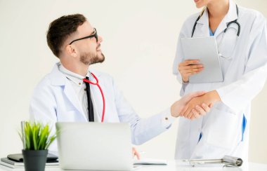 Hastanedeki doktor başka bir doktorla el sıkışıyor