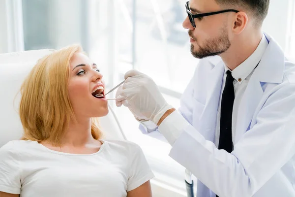 Young dentist examining patient in dental clinic. — Stock Photo, Image