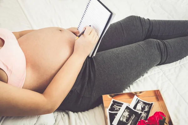 Mujer embarazada feliz y esperando un bebé en casa. — Foto de Stock