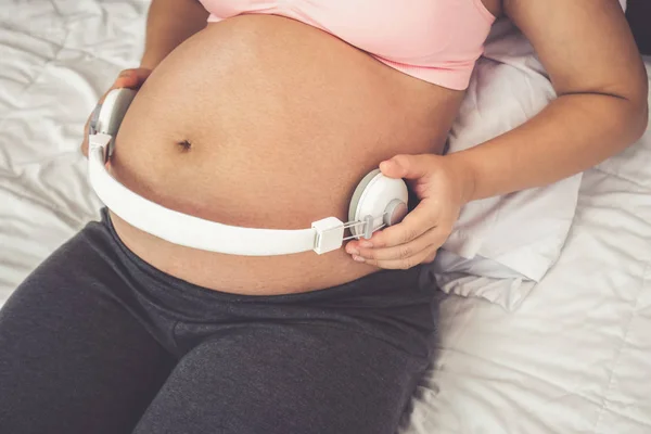 Mujer embarazada feliz y esperando un bebé en casa. — Foto de Stock