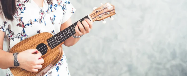 Boldog asszony zenész játszik ukulele stúdióban. — Stock Fotó