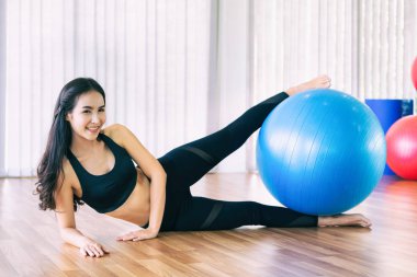 Fitness topu ile genç kadın pilates egzersizi.