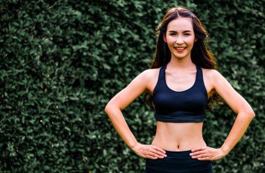 Genç spor kadını parkta sabah egzersizi yapıyor.