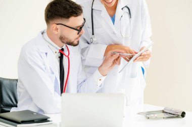 Hastanedeki doktor ortağıyla bilgisayar başında çalışıyor.