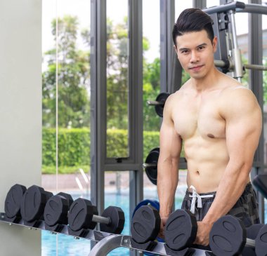 Kaslı adam vücut geliştirmeci dumbbells ile eğitim.