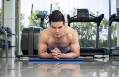 Genç adam vücut geliştirmeci fitness merkezinde itmek.