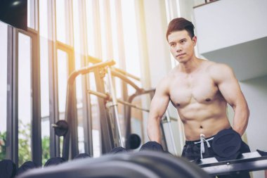 Kaslı adam vücut geliştirmeci dumbbells ile eğitim.